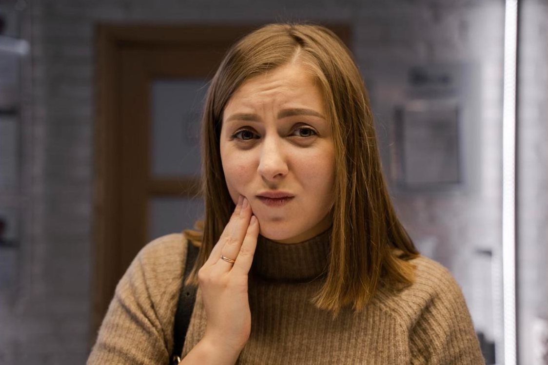 Femme souffrant d'une douleur dentaire se tenant la joue